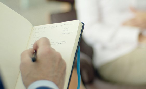 A hand writting in an open notebook